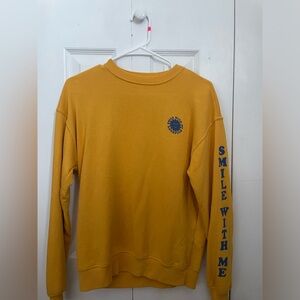 Yellow small bilibaong crewneck. Blue sun and arm details.